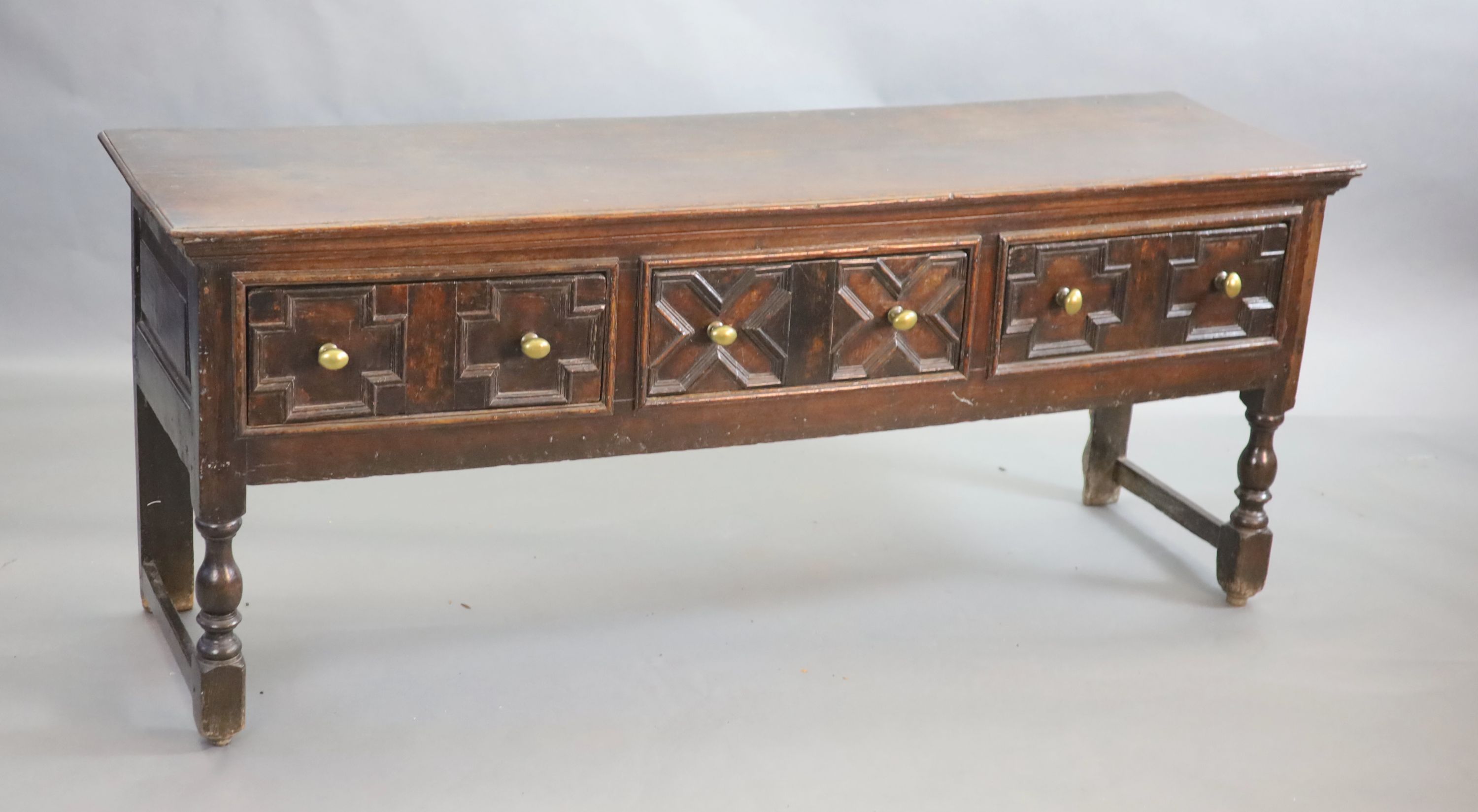 A late 17th century oak dresser fitted three short drawers raised on turned legs